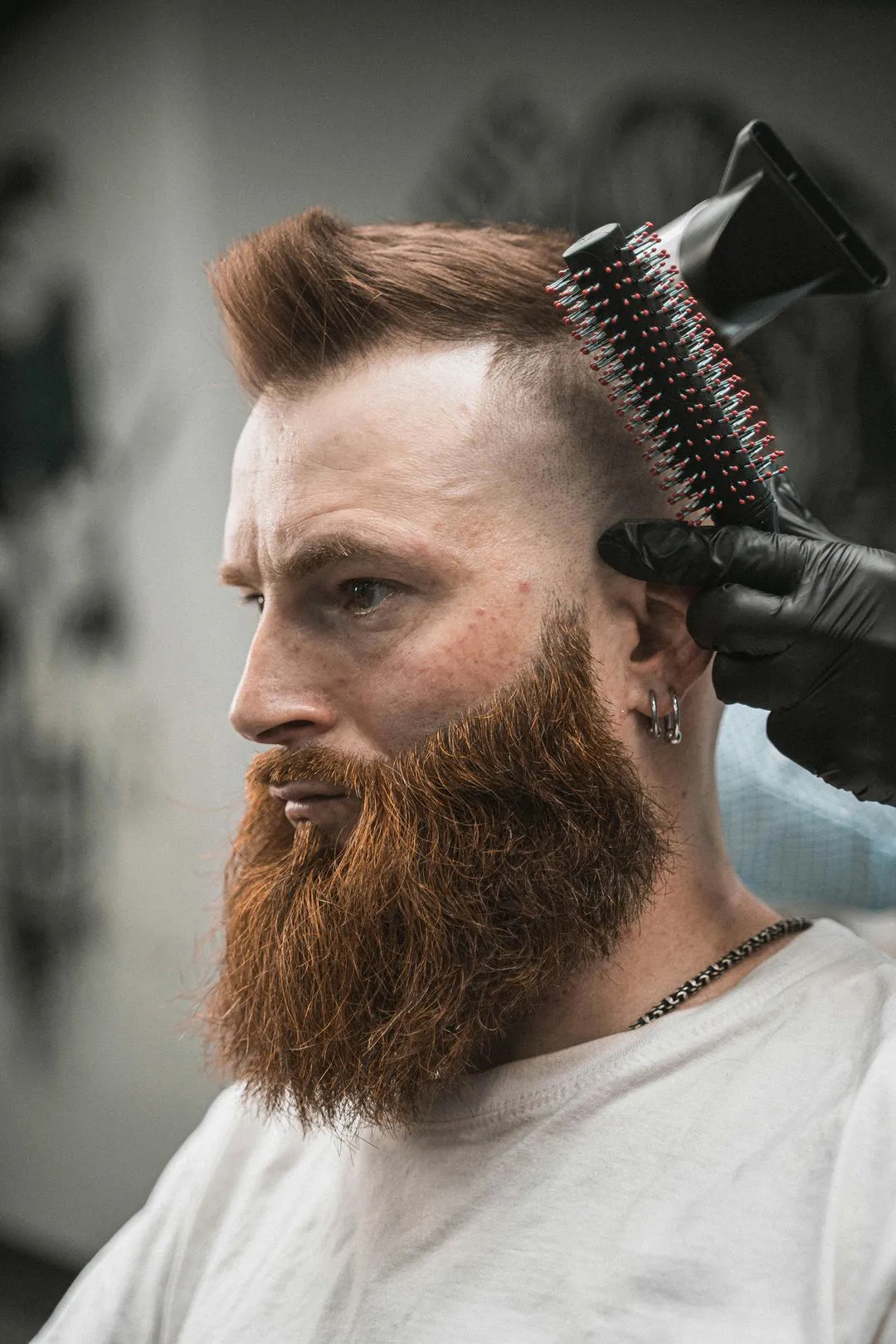 Barber styling a red-bearded man's hair